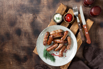 Bavarian sausages. Pork sausages in a plate on a brown wooden table. Delicious Nuremberg sausages	