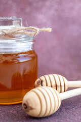 Glass can full of honey and wooden stick