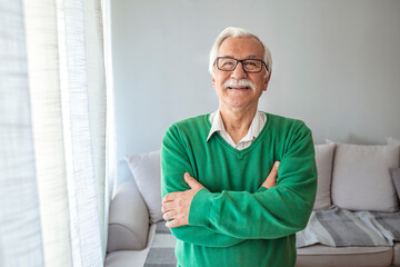 Close-up portrait of happy senior man looking at camera. Portrait elderly man at home. Elderly Man...