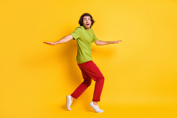 Fototapeta na wymiar Full length body size photo of man going tiptoes looking nervous afraid thief escape isolated on bright yellow color background