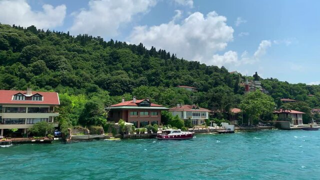 Footage of luxury houses in upscale neighborhood called "Kandilli" by Bosphorus in Istanbul. It is a beautiful summer scene on cloudy summer day. Camera moves forward.