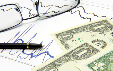 Dollar paper money, glasses, pen, chart. Stock business.