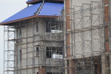 New construction site with crane Sunset sky background Steel frame structure, steel beam Building a...