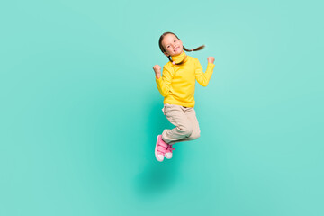 Fototapeta na wymiar Full body photo of brown haired happy girl jump air lucky sale raise fists wear yellow jumper white pants isolated on teal color background