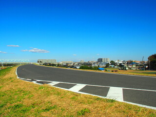 ゼブラゾーンのある秋の江戸川土手のサイクリング道路風景