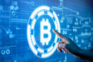 Hand clicks on futuristic display with bitcoin cryptocurrency image