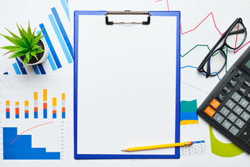 Tablet with paper for copy space on graphics and reports with graphs