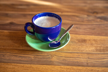 Blaue Tasse Kaffeetasse und grüner Teller Untertasse mit Kaffee und Löffel