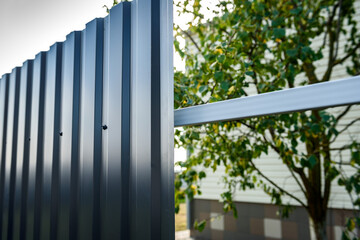Installation of gray fence from metal profile.