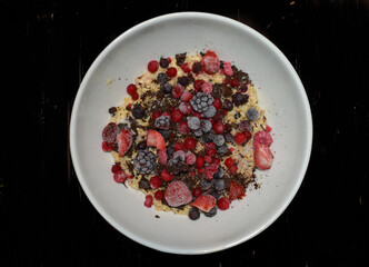 Bowl of oatmeal pudding with chocolate and berries.