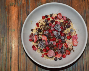 Bowl of oatmeal pudding with chocolate and berries.
