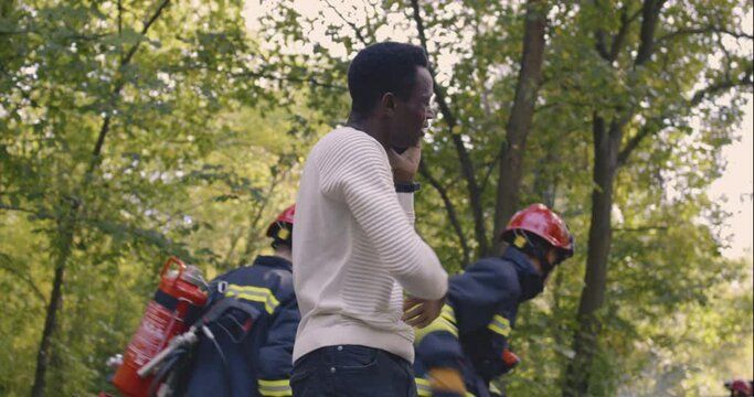Wounded black victim showing firemen crashed car