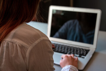 young woman working or studying from home.,with a book and laptop during lockdown. selective focus