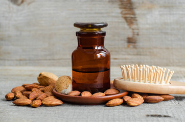Pharmacy bottle with almond oil and wooden hair brush. Natural hair care concept. Old wooden...