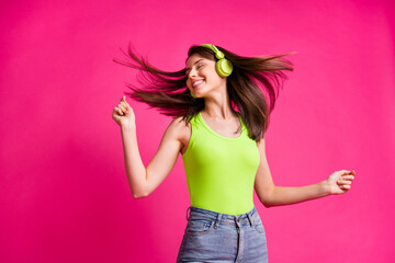 Photo of happy cheerful young girl listen music headphones dance enjoy happy fun isolated over pink color background