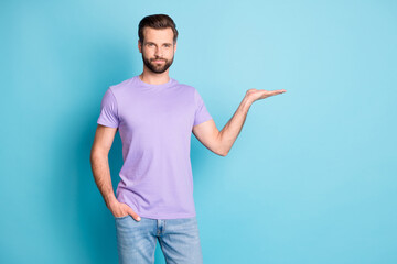 Photo of young attractive man hold hand demonstrate present product advert isolated over blue color background