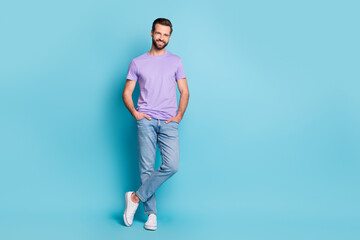 Fototapeta na wymiar Full body photo of young cheerful man confident happy smile hands in pocket isolated over blue color background