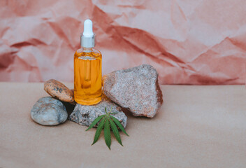 Glass bottle and dropper CBD OIL, THC tincture and cannabis leafs on pastel background. Laboratory...