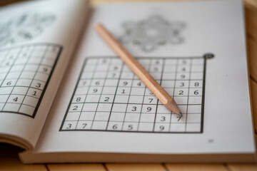 sudoku (crossword) puzzle and pencil. Selective focus.