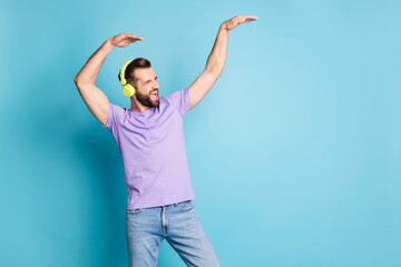 Photo of young excited crazy man have fun enjoy radio music dance look empty space isolated over blue color background