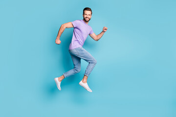 Fototapeta na wymiar Full length body size side profile photo of young bearded student jumping high running isolated on vibrant blue color background