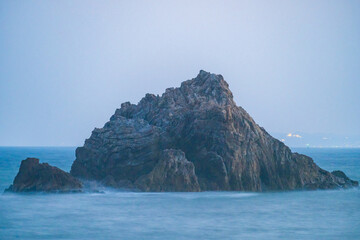 海岸の大きい岩と夕日