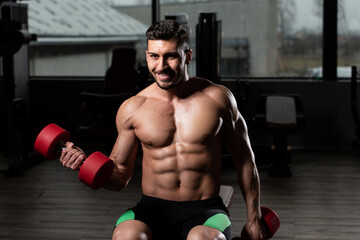 Naklejka na ściany i meble Bodybuilder Exercising Biceps With Dumbbells