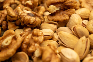 Pistachios and walnuts lie on the sacking. Close up.