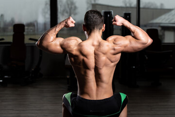 Fototapeta na wymiar Muscular Men is Hitting Back Double Bicep Pose