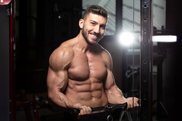 Fototapeta na wymiar Man Exercising Biceps In The Gym