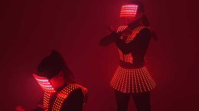 Two sexy female disco dancers moving in UV costumes