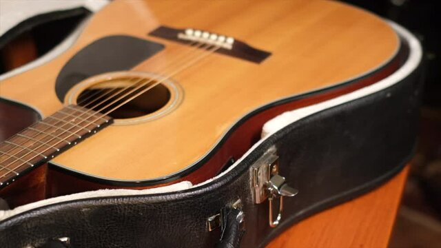 Close frame of male hands opening guitar case  