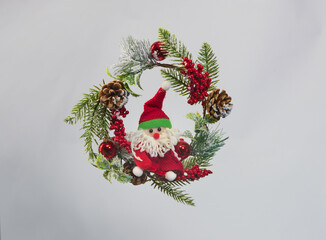 A Figure of Santa Claus on a Christmas wreath on a light background.