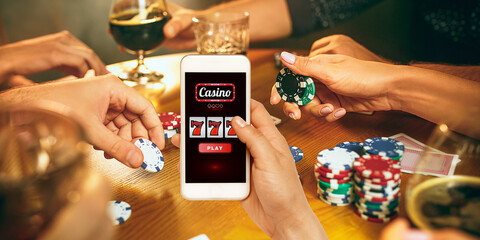 Online gambling, casino concept. Hand holding device with lottery, casino cover. Playing dips and...