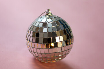 silver disco ball reflecting lights on pink background, greeting card with sparkles template, empty...