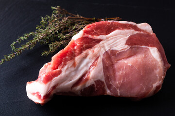 Food concept raw pieces  of  pork shoulder  on black slate stone board with copy space
