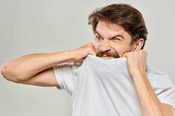 man in white t-shirt emotions expressions gesture with hands cropped view light background