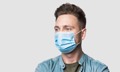 Young man wearing protective face mask studio isolated portrait, social distancing, pandemic, corona virus protection, healthy lifestyle, people concept