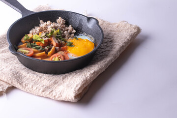 Pan-fried eggs in a black pan on a gray background.