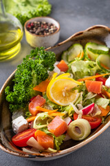 Salmon salad with fresh vegetables and cheese. Closeup