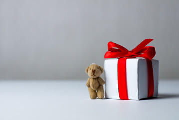 White gifts with red ribbons with a little teddy bear. gift box isolated on white background.Christmas gift boxes on white background. Merry Christmas and Happy Holidays greeting card, frame, banner.