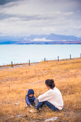 Madre con hijo sentada junto al lago