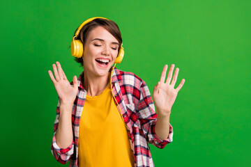 Photo of funky pretty short hairstyle lady listen music closed eyes dancing wear yellow cloth isolated over vivid green color background