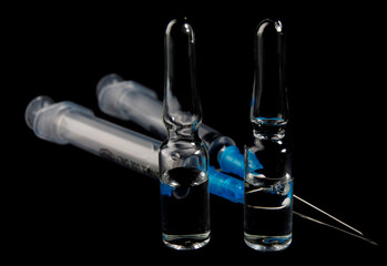 Syringes and ampoules with medicine on a black background. Vaccine.