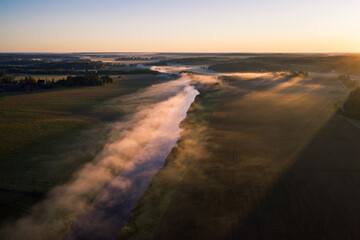 Fototapeta na wymiar Aerial view of fog above a river valley at dawn