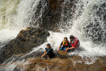 Asian family refreshing in Lasir Waterfall in Lake Kenyir, Terengganu Malaysia.