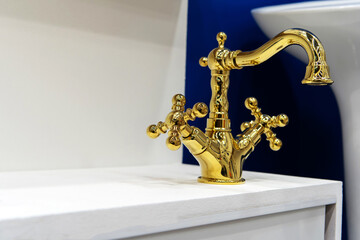 Gold colored water tap. Plumbing trade in a store. Selective focus