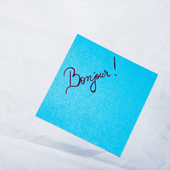 Text Bonjour on post it. Writing on colorful sticky note. Bucharest, Romania, 2020. © Vlad Ispas