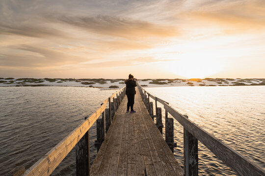 Long distance view of a photographer on the bridge of Mari Ermi at sunset