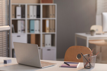 Image of laptop on empty desk at modern empty office